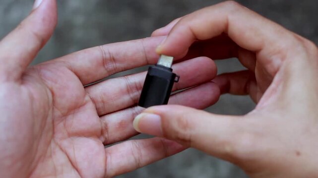 Close-up video of a hand holding a USB Type A to USB Type C adapter. Technology accessory concept showing connectivity, data transfer, and modern device compatibility.