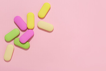 Colorful rubber erasers on pink background
