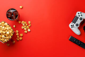 Popcorn, cola and gamepad on red background © evgeeenius
