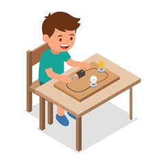 A boy sitting at a table with a light bulb and a device on it
