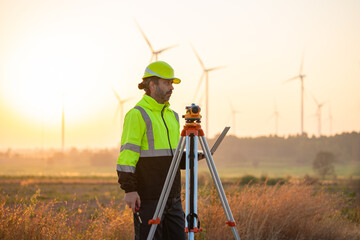 Engineer wearing uniform inspection and survey work in wind turbine farms rotation to generate electricity energy. Maintenance engineer working in wind turbine farm at sunset.