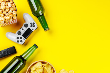 Popcorn, potato chips, beer and gamepad on yellow background © evgeeenius