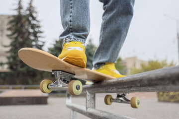 Legs of young man with skateboard in skatepark, closeup © Pixel-Shot