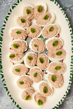 stuffed eggs and green leaves on a oval plate, image from above