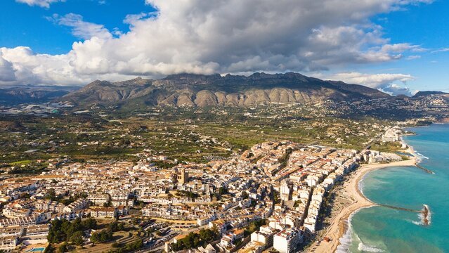 Altea coastline with church, beach and mountains under dramatic clouds, Costa Blanca, Alicante, Spain