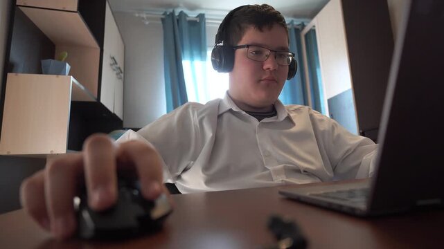 Teenager with headphones is sitting at a laptop the concept of online learning