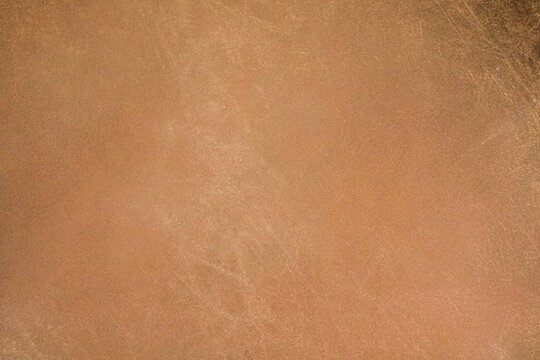 A clean, overhead view of a warm tan or light brown finish. The texture is characterized by a subtle, fine grain and light scuff marks that give it a lived-in, natural feel.