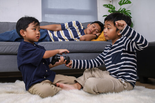 Two Boys Fight Over Controller While Their Dad Sleeps on the Couch