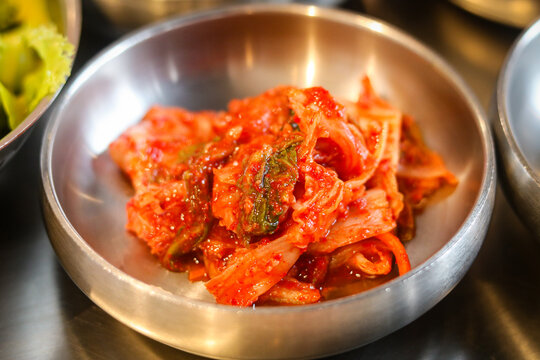 Closeup view of Kimchi, the iconic Korean fermented cabbage in a bowl. This traditional and healthy food is a staple of Korean cuisine. A bold, spicy, and savory flavor profile.