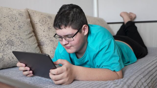 Sick Young Man with Tablet Computer on the Bed