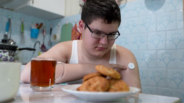 A teenager with diabetes eats candy to control low blood sugar, illustrating sugar harm and diabetes risk. A diabetic raises low blood sugar levels.
