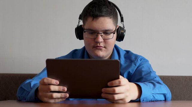 view video content online. man with headphones at home and holding smartphone, is connecting online and social networking