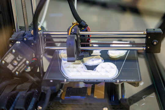3D printer creating plastic objects with precision and speed. The concept represents modern manufacturing, rapid prototyping, and the future of custom production.