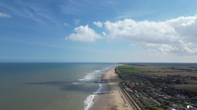 Aerial view over Walcott village looking towards North Sea coastline on clear sunny day Norfolk