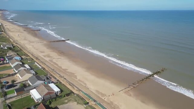 Aerial view of Walcott Beach coastline with village farmland and sea on sunny summer day Norfolk