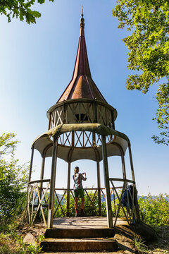 Woman taking photo in pavilion surrounded by nature in Eifel Germany
