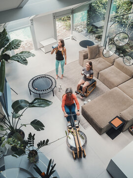 Family working out together in modern living room with rowing machine