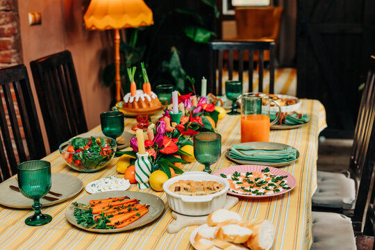 Festive Easter dinner table with traditional family food and flowers at home