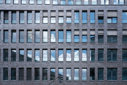 Modern urban office architecture building facade with windows creating symmetry in grid pattern and clean minimal repetition across corporate exterior
