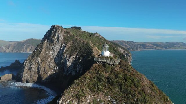 Aerial drone view of Nugget Point lighthouse on dramatic coastal cliffs in Otago New Zealand