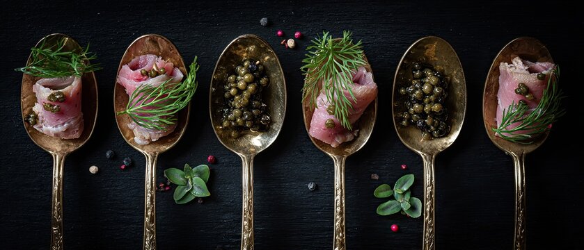 Duck galantine in spoons on a dark background, prepared according to a recipe of modern molecular cuisine.