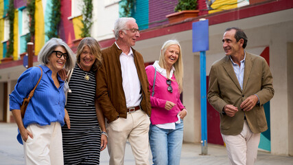 Obraz premium Senior friends laughing walking together in city