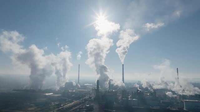 High drone panorama of the &Scaron;tět&iacute; industrial area with multiple chimneys, large circular basins, and the nearby river corridor visible at the edge of the frame.