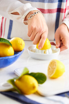woman hands squeezing a lemon in a lemon squeezer
