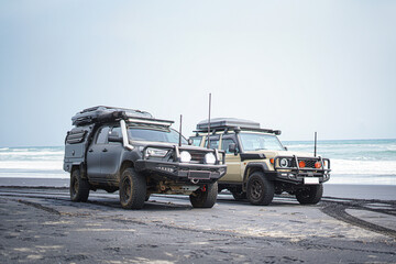 Overland 4x4 off-road vehicles parked on beach coastline © Tino Nugroho