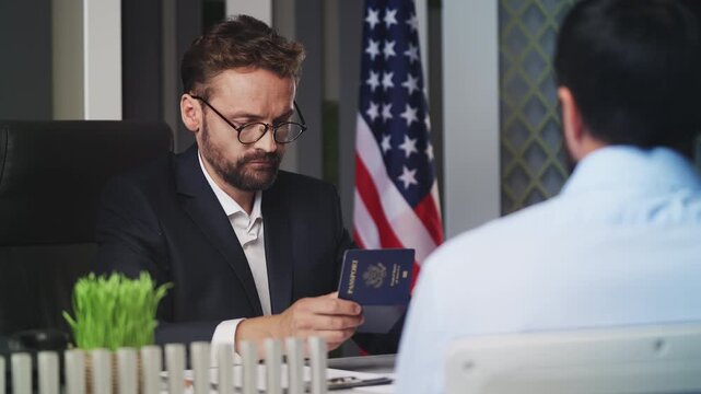 U.S. embassy employee approving an application and handing passport to male