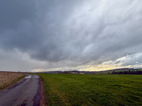 Dramatic stormy clouds over rural countryside road in Belgium's Hautes Fagnes region