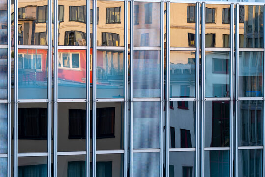 Modern urban architecture with facade windows showing reflection of a tram in colorful city light in Frankfurt Germany financial district street scene