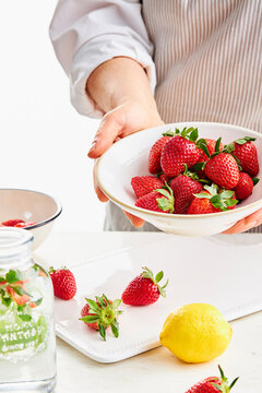 woman holding a bowl with strawberries