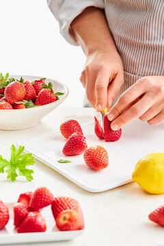 woman hands cutting strawberries with a knife