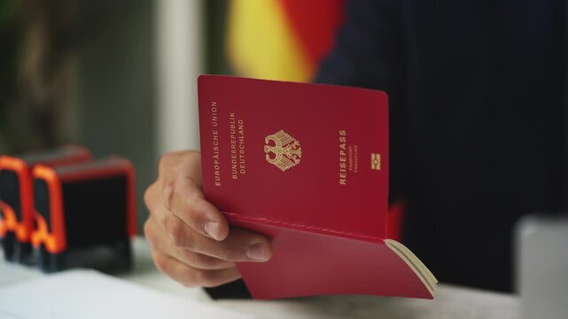 Close-up of male embassy worker reviewing German passport data on laptop