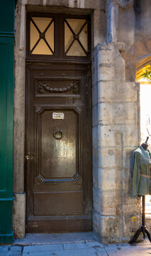 Lyon, France. December 28, 2023. An ancient traboule door: a pedestrian passageway crossing private courtyards, made of wood with a historic knocker, set in a rustic stone wall.