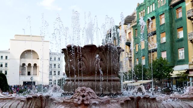 Large ornate stone fountain with jets spraying in a Timisoara square, Romania