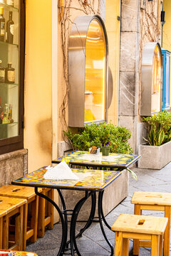 Empty outdoor cafe with minimalist design and traditional mosaic table in Palermo street. Mediterranean architecture and relaxed Italian lifestyle atmosphere. Concept of travel destination, slow touri