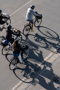 Street traffic in urban Copenhagen Denmark with cyclists and bicycles seen overhead making shadows that highlight the daily commute flow