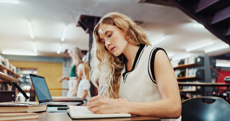 Woman, student and writing with book in library for studying, education or learning in school. Female person, university or taking notes with diary or notebook for project research or assessment © peopleimages.com