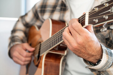 Man playing an acoustic guitar at home