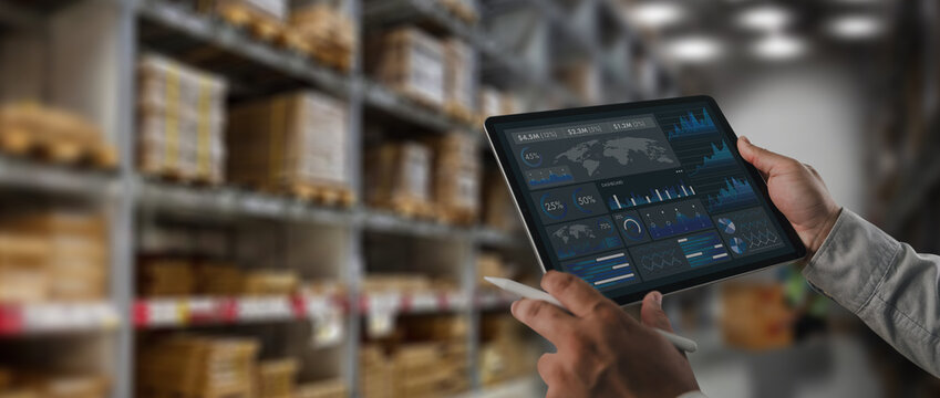 Logistics manager analyzing supply chain data dashboard on tablet inside warehouse storage facility. Concept of logistics analytics, inventory monitoring, digital warehouse management and technology d