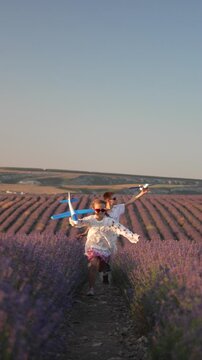 Children Lavender Playing kids running with toy planes in purple field at sunset Vertical video