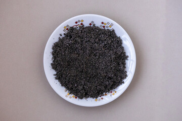 Top view of spoiled Black Cumin seeds with white mold and fungus growth on a plate. A close-up of food waste, improper storage, and decomposition, illustrating food safety and contamination