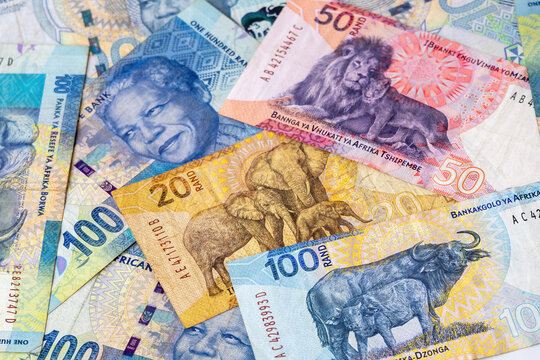 Close-up of scattered south african rand banknotes, including one hundred, fifty, and twenty bills. Currency of south africa featuring nelson mandela, and african wildlife for economy concept.