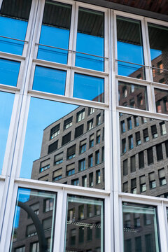 Modern office architecture window grid with glass reflection forming an urban pattern and strong symmetry on a corporate building facade