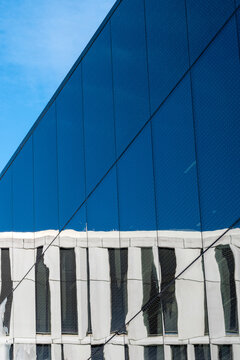 Blue modern architecture facade with glass panels and abstract lines creating a minimal corporate building look with strong geometry