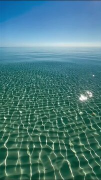 eye level view of crystal clear turquoise ocean water with caustics light ripples