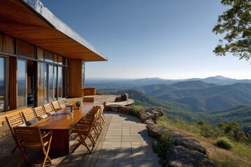 Obraz premium Mountain view from a wooden deck at a house during a sunny day with clear skies above the landscape of rolling hills and distant mountains