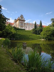 Obraz premium Scenic view of Pruhonice Castle in a sunny summer day with beautiful reflection in the pond,